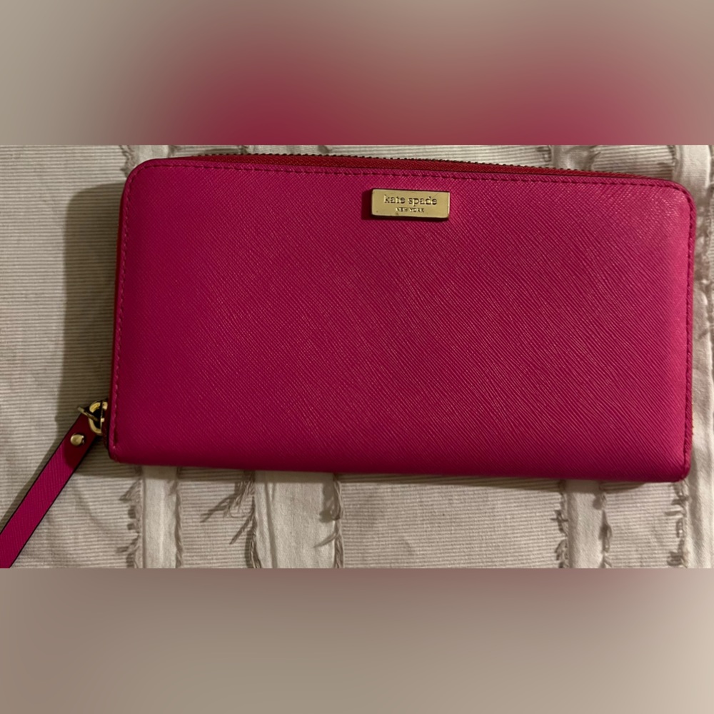 Hot pink Kate Spade continental wallet with multi colored striped clothe inside